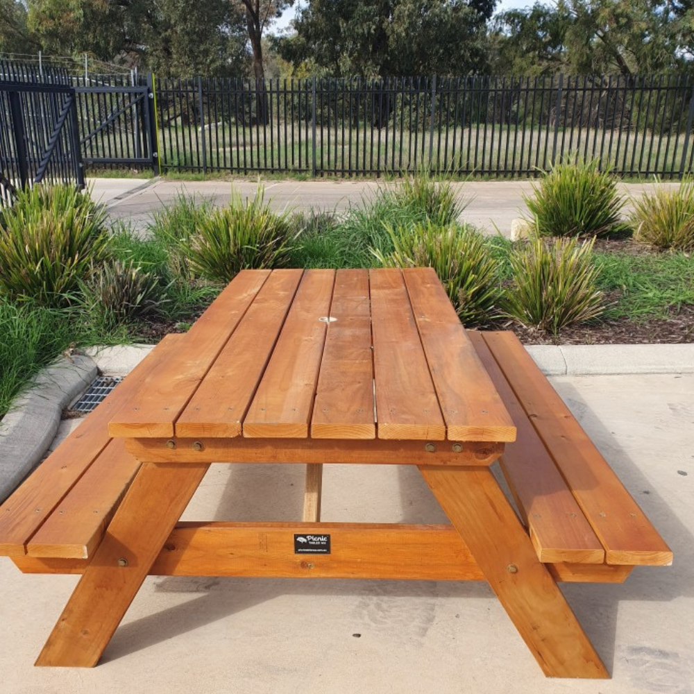Traditional Pine picnic table in a commercial setting with grass and plants around