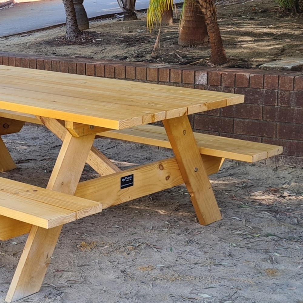 Close up of an A Frame Pine picnic table on Sand.